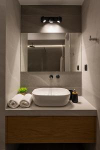 a bathroom with a white sink and a mirror at Amara Local Experience in Chania Town