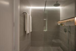 a bathroom with a shower with a glass door at Amara Local Experience in Chania Town