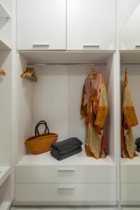 a walk in closet with white cabinets and a basket at Amara Local Experience in Chania Town