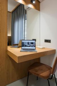 a laptop computer sitting on a wooden desk with a chair at Amara Local Experience in Chania Town