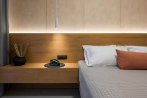 a bed with a wooden headboard with a hat on it at Amara Local Experience in Chania Town