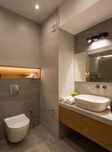 a bathroom with a sink and a toilet and a mirror at Amara Local Experience in Chania Town