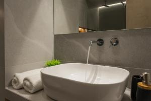 a white sink in a bathroom with a mirror at Amara Local Experience in Chania Town