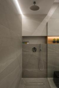 a bathroom with a shower with a glass door at Amara Local Experience in Chania Town