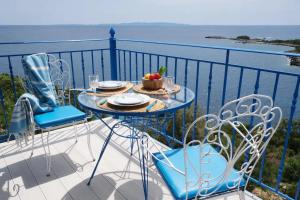 a table and chairs on a balcony with a view of the ocean at Kassandra in Sivota