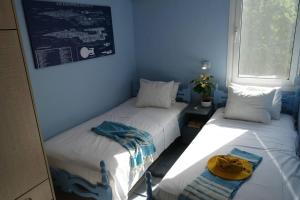 two beds in a room with blue walls at Kassandra in Sivota