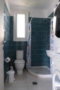 a bathroom with a toilet and a shower and a sink at Kassandra in Sivota