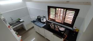 a small kitchen with a stove and a window at Angel Beach Villas - Pondicherry in Puducherry