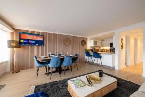 a living room with a table and blue chairs at Cosy Home Center 1850-Croisette in Courchevel