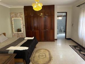 Un dormitorio con una cama y un gran armario de madera. en kim luxury home, en Kampala
