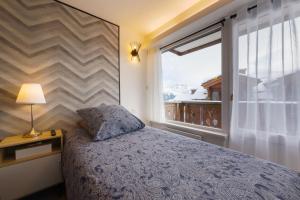 a bedroom with a bed and a large window at Cosy Home Center 1850-Croisette in Courchevel