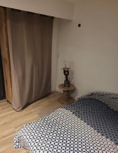 ein Schlafzimmer mit einem Bett und einem Tisch in einem Zimmer in der Unterkunft Chambre lit 2 personnes in Saint-Martin-lez-Tatinghem