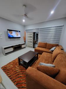 a living room with a couch and a flat screen tv at Accra Apartments in Accra