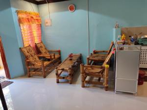 a room with chairs and a refrigerator in a kitchen at Beachfront Agpangi in Naval