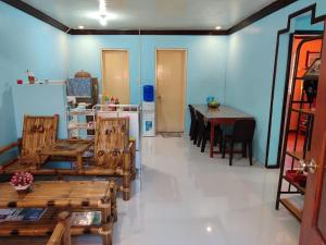 a room with chairs and a table and a refrigerator at Beachfront Agpangi in Naval