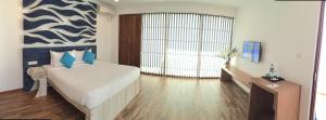 a bedroom with a large bed and a large window at Binnacle Negombo in Negombo