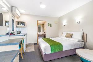 ファンガレイにあるBella Vista Motel Whangareiのベッドとキッチンのある小さな部屋