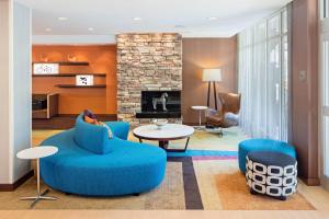 a living room with blue furniture and a fireplace at Fairfield Inn & Suites by Marriott North Bergen in North Bergen