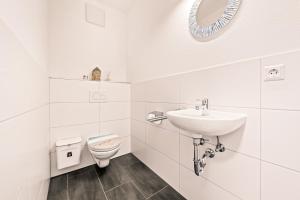 een witte badkamer met een wastafel en een toilet bij Apartment Nautilus in Seenähe in Friedrichshafen