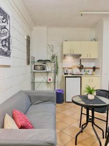 ein Wohnzimmer mit Sofa und Tisch in der Unterkunft 504 Lovely Cosy Private Studio Apartment Central in Melbourne