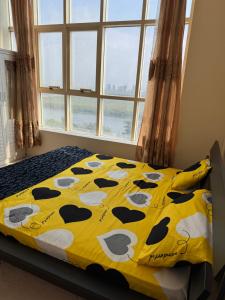 een bed met een gele deken met koeien erop bij Stunning Corniche view in Ras al Khaimah