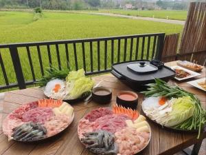 a wooden table with four plates of food on it at PoolVilla3 พักได้7ท่าน 3ห้องนอน4ห้องน้ำ in Doi Saket