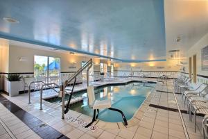 a swimming pool in a hotel room with chairs at Fairfield Inn & Suites by Marriott Milwaukee Airport in Oak Creek