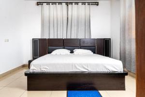 洛美Sublime modern villa的卧室里有一张带木质床头板的大床