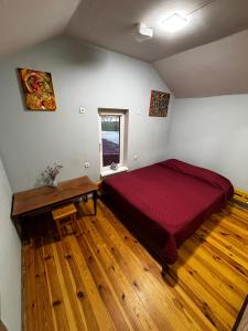a bedroom with a red bed and a wooden floor at Red Star Peoples Republic in Tiraspol