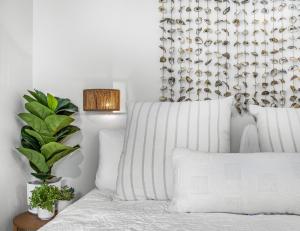 a bedroom with a bed with white sheets and a plant at Talleyrand in Bar Harbor