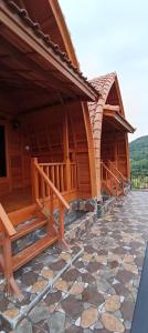 a couple of wooden buildings with a stone floor at Giri Swari Homestay in Sidemen +20 photos