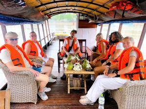 a group of people sitting in chairs on a boat at Hide Away Bungalows in Ben Tre City in Ben Tre