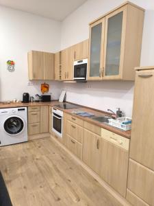 una cucina con armadi in legno e un apparecchio bianco di Patricia Apartman a Keszthely