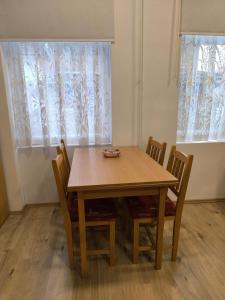 un tavolo e delle sedie in una stanza con una finestra di Patricia Apartman a Keszthely Altre 5 foto