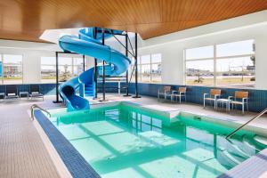 an indoor swimming pool with a slide in a building at Delta Hotels by Marriott Grande Prairie Airport in Grande Prairie