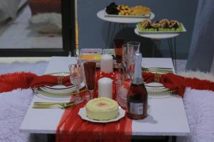 a table with a cake and a bottle of wine at Marula Tree Lodge in Moletlane