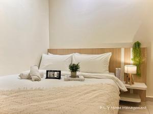 a bedroom with a large white bed with a clock on it at Ipoh Town CityView Premium Suite Kampung Paloh Residensi in Ipoh