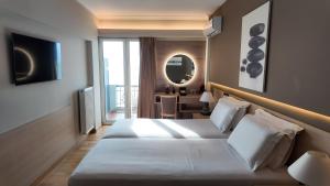 a hotel room with two beds and a mirror at Coral Hotel Athens in Athens
