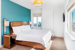 a bedroom with a large bed and a blue wall at Element by Marriott Calgary Airport in Calgary +16 photos
