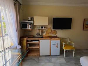 a small kitchen with a desk and a tv on the wall at Gibralfaro Alojamiento Turístico cerca de la playa in Málaga +7 photos