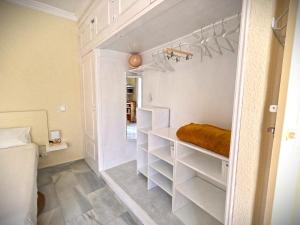 a small bedroom with white shelves and a bed at Gibralfaro Alojamiento Turístico cerca de la playa in Málaga