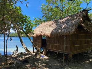 a hut on the shore of a body of water at Yenaiwon Homestay Raja Ampat in Yariffi