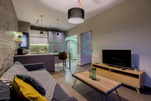 a living room with a couch and a tv at Sea view luxury apartment in Alexandroupoli