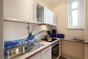a kitchen with a sink and a counter top at Appartement & Ferienwohnungen Thiess in Rostock +33 photos