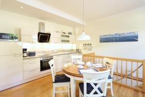 a kitchen and dining room with a table and chairs at Appartement & Ferienwohnungen Thiess in Rostock