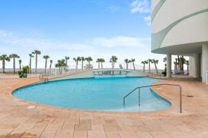 a swimming pool in a resort with palm trees at Turquoise C702 in Orange Beach