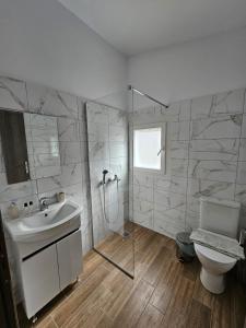 a bathroom with a shower and a sink and a toilet at Studios Iris in Pramanta