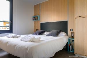 a bedroom with a large bed with white sheets and pillows at Cottages du Golf Fleuray-Amboise in Cangey +46 photos