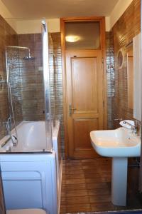 Un baño con bañera, lavabo e inodoro. en La casa di Juliette, en Merone 14 fotos más