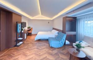 una camera d'albergo con un letto e un divano di 南浔浔溪之畔民宿 a Huzhou
